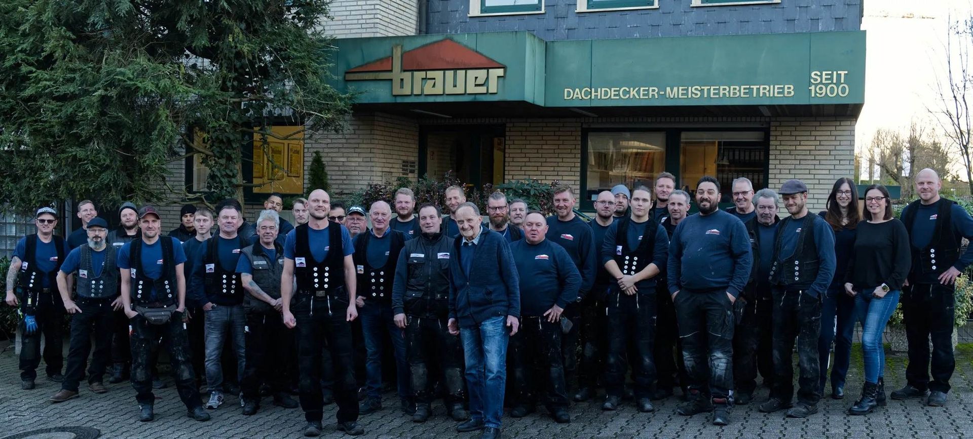 Team der Dachdeckerei Brauer vor dem Firmengebäude